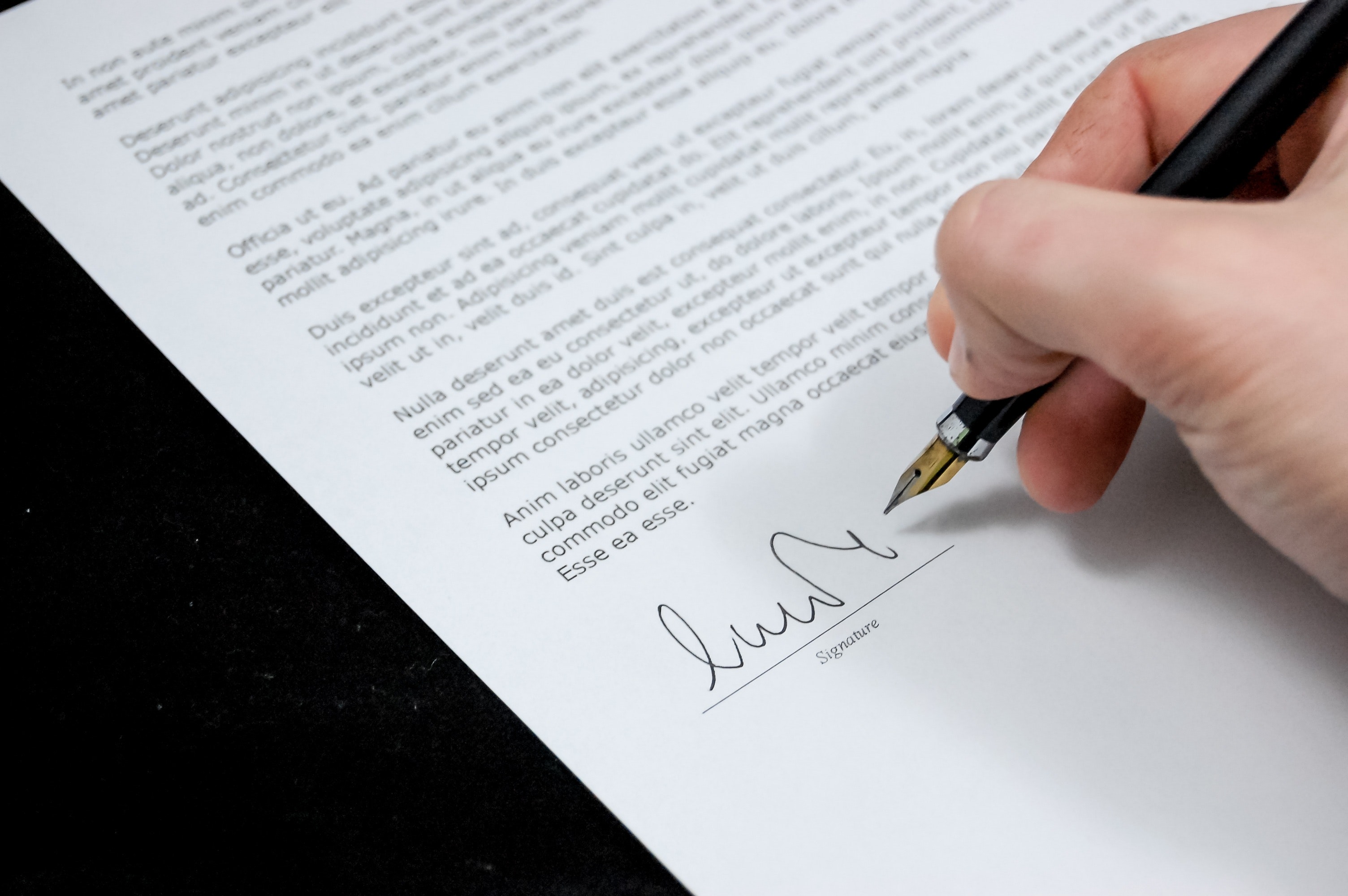 Close up of person signing a contract